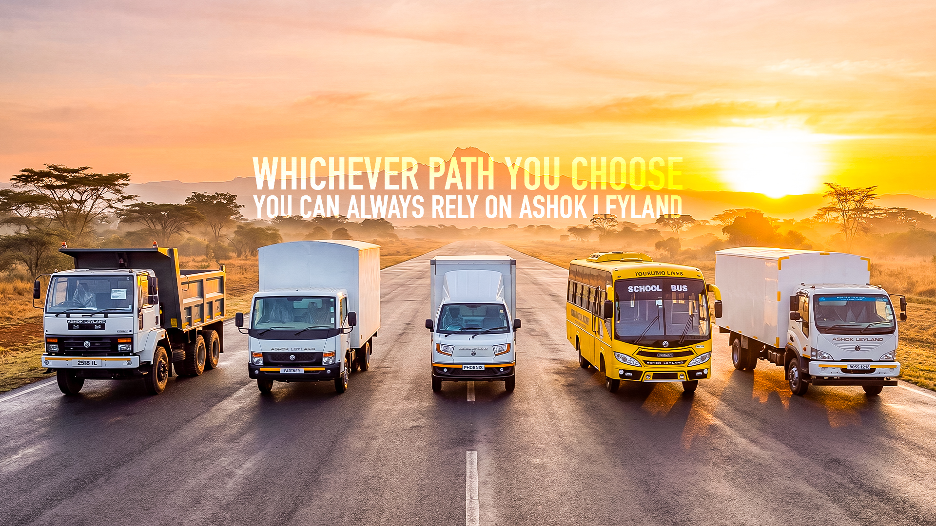 Ashok Leyland truck and bus lineup on a Kenyan highway at sunrise