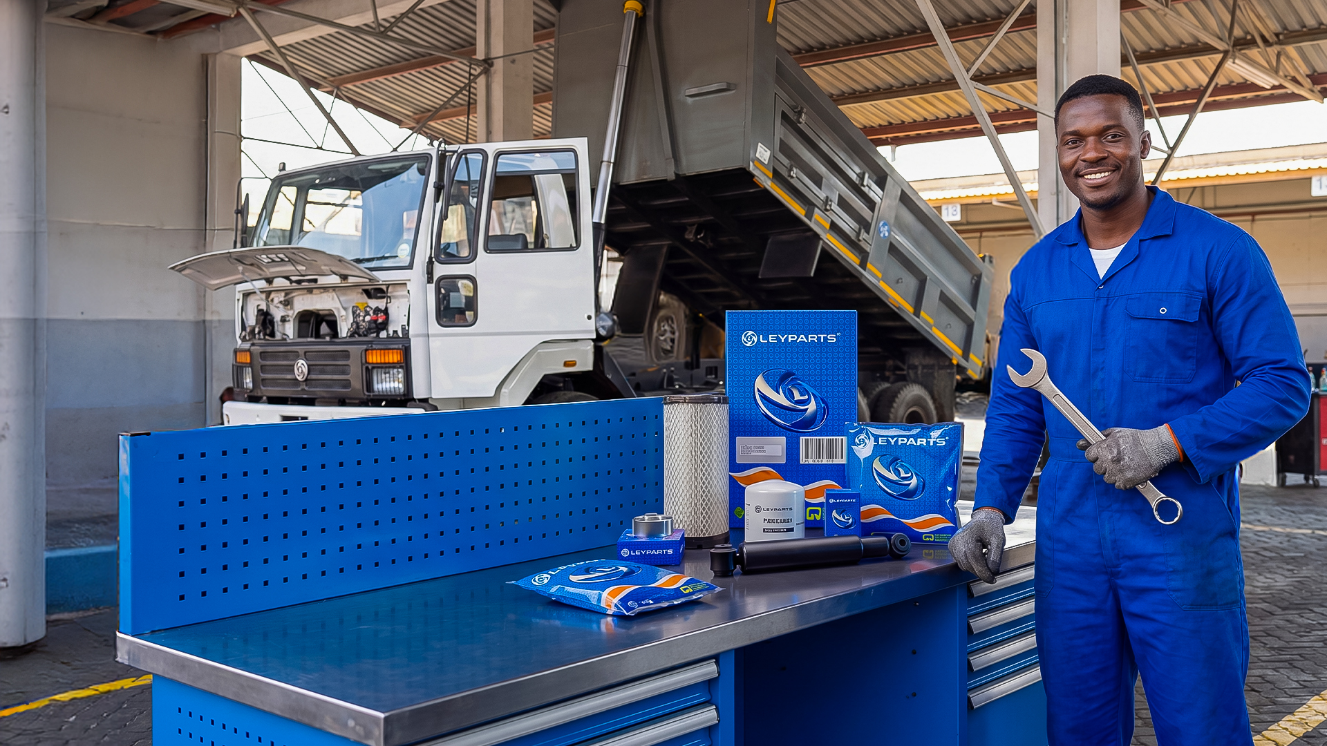 Ashok Leyland technician with genuine Leyparts spares at a Simba Corp service bay